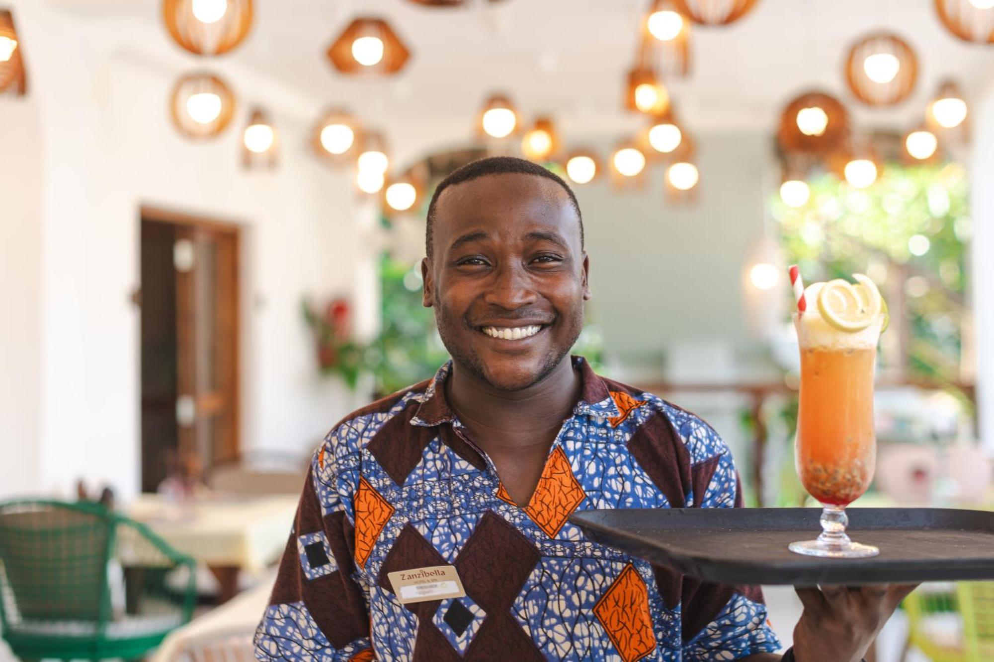 Zanzibella Hotel & Spa キウェンワ エクステリア 写真 A waiter at the Serena Hotel in Kampala, Uganda